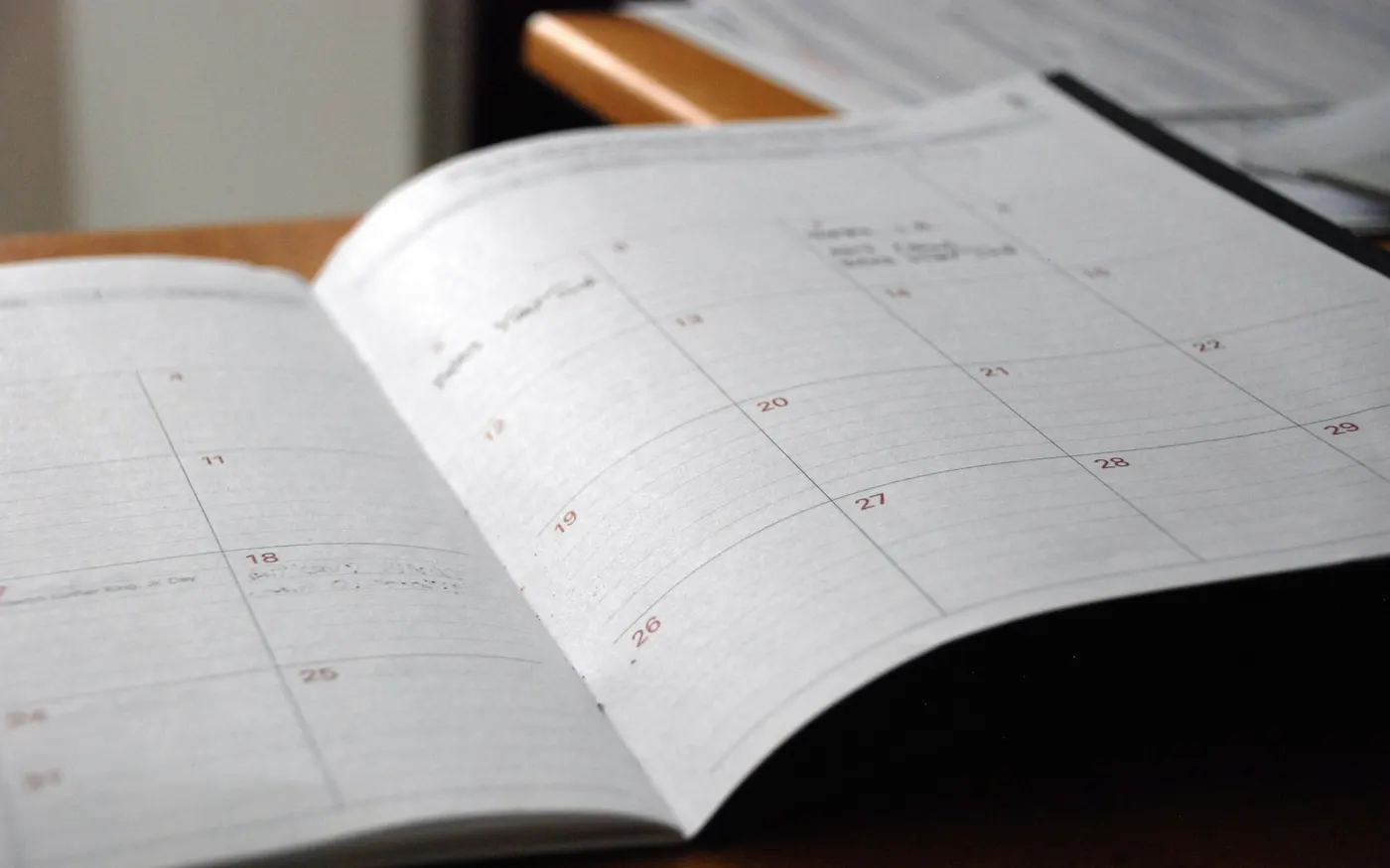 Agenda mensuel ouvert sur un bureau, utilisé pour suivre les séances et les trajets d'un service