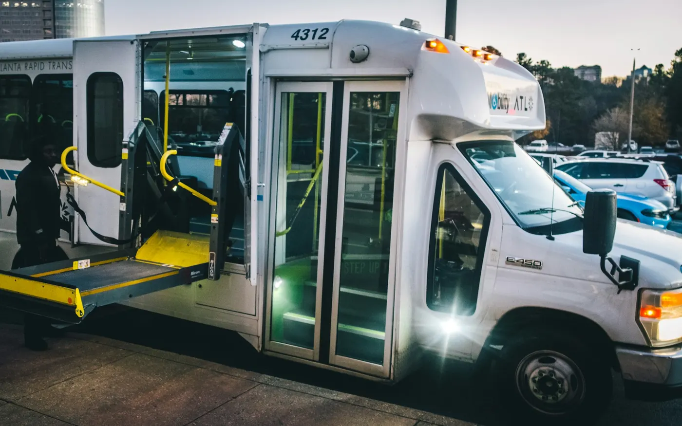 Véhicule de transport aux portes ouvertes, rampe d'accès déployée pour la montée d'un fauteuil roulant