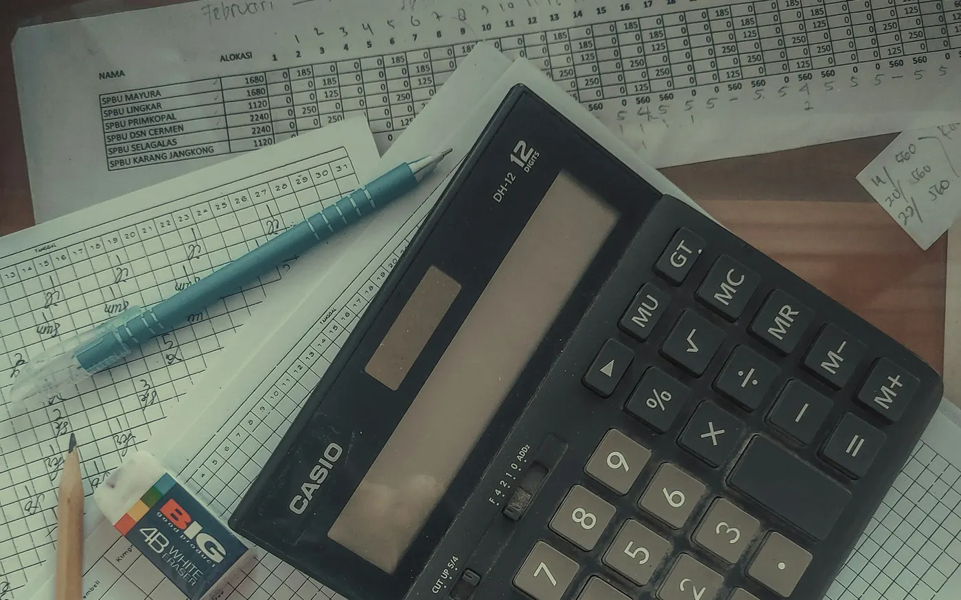Calculatrice posée sur une pile de factures de transporteurs à contrôler avant paiement